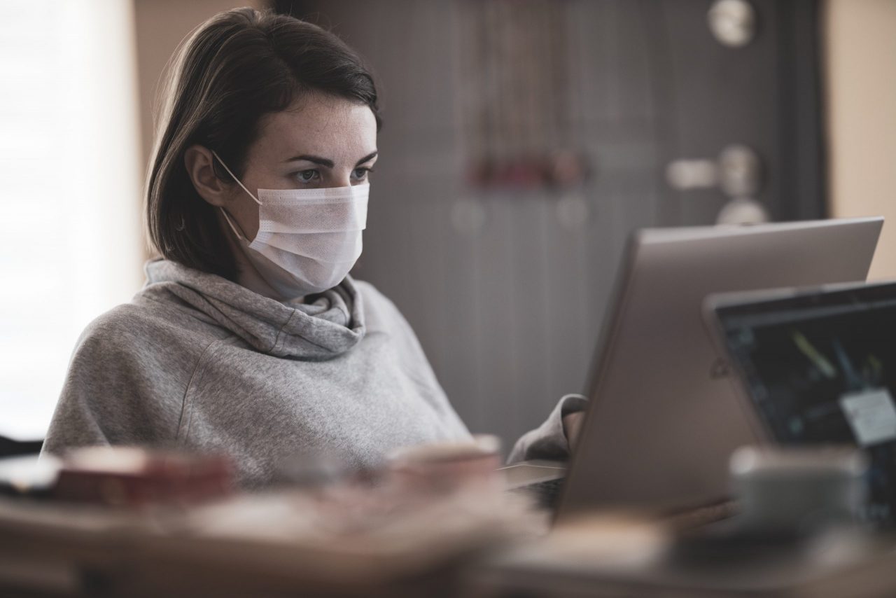 Woman wearing mask working from home